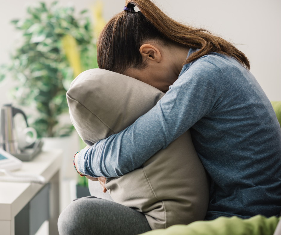 Overwhelmed young lady with her head in a pillow